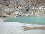 307 Annapurna North Base Camp At Beginning Of Miristi Khola We arrived at the first French Base Camp (4190m) at 12:15, 3 hours after leaving our Miristi Khola camp . �Schatz and I arrived at Base Camp, which was pitched among the moraines in the midst of  a vast stony desert with little blue-green lakes dotted about in the hollows� (Maurice Herzog, Annapurna). The first French Base Camp is in a nice location at the foot of the north Annapurna Glacier next to a beautiful aquamarine glacial lake, the beginning of the Miristi Khola. It's on an area covered with brown covered gray sand and scattered strands of grass.